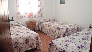 Ein Schlafzimmer mit zwei Betten, einem Nachttisch, einer Lampe und einem Bild an der Wand.