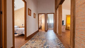 Un pasillo con baldosas de diseño, vigas de madera y paredes de ladrillo.