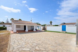 A house with a tiled roof, a patio with stone flooring, and a blue door. - Beautiful villa with pool and garden (CONIL DE LA FRONTERA)