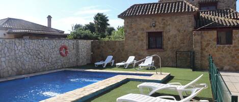 Een binnenzwembad, ligstoelen bij het zwembad