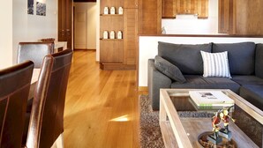A modern living room with a grey sofa, wooden cabinets, and a coffee table with decorative items. - Val de Ruda Luxe 21 by FeelFree Rentals (Baqueira)