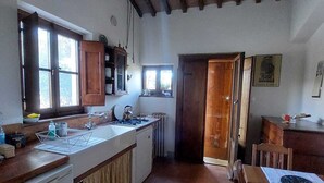 Eine Küche mit Holztisch, Spüle und Fenster.