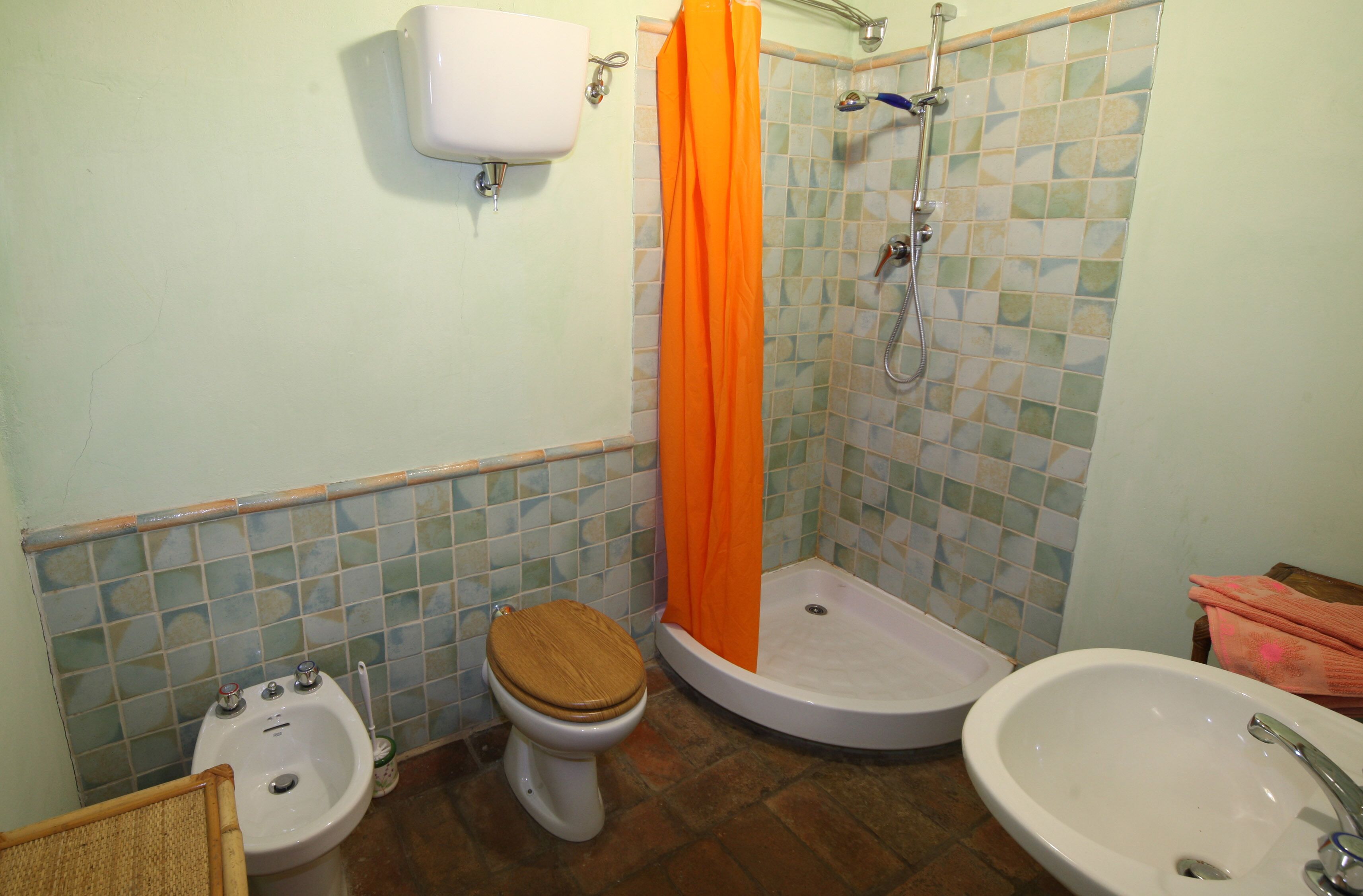 Ein Badezimmer mit Toilette, Bidet, Dusche und Waschbecken.