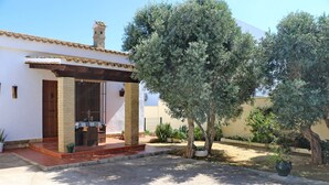 A house with a tiled roof, a wooden door, and a small porch with a table and chairs. - 4 person holiday villa with private pool (CONIL DE LA FRONTERA)
