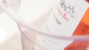 A bottle of Chateau Bas wine with a label that includes a vineyard illustration and the text "Chateau Bas" and "Alvergne." - SunlightProperties AMOUR VIOLETTE: Hyper Center, 2 bedroom apt with terrace (Nice)
