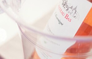 A bottle of Chateau Bas wine with a label that includes a vineyard illustration and the text "Chateau Bas" and "Alvergne." - SunlightProperties AMOUR VIOLETTE: Hyper Center, 2 bedroom apt with terrace (Nice)