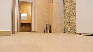A hallway with a tiled floor, a brick wall, and a patterned wall. - Rural apartment for four people (CONIL DE LA FRONTERA)