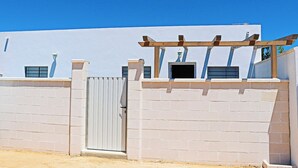 A white building with a gated entrance, a pergola, and a small window. - Rural apartment for four people (CONIL DE LA FRONTERA)