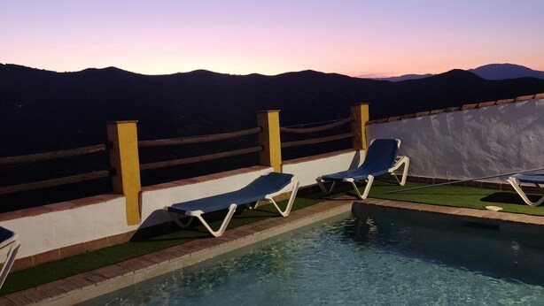 A pool with lounge chairs, a view of mountains, and a clear sky. - 6 bedroom holiday house in Almachar (ALMACHAR)