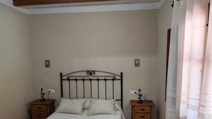 A bedroom with a bed, two nightstands, and a wooden headboard. - 6 bedroom holiday house in Almachar (ALMACHAR)