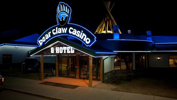 Un edificio con un letrero de neón que dice 'Bear Claw Casino & Hotel'.