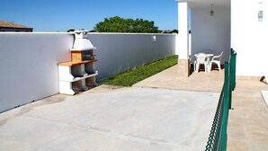 A patio with a barbecue grill, a small table, and chairs. - Villa with private pool in rural area (CONIL DE LA FRONTERA)