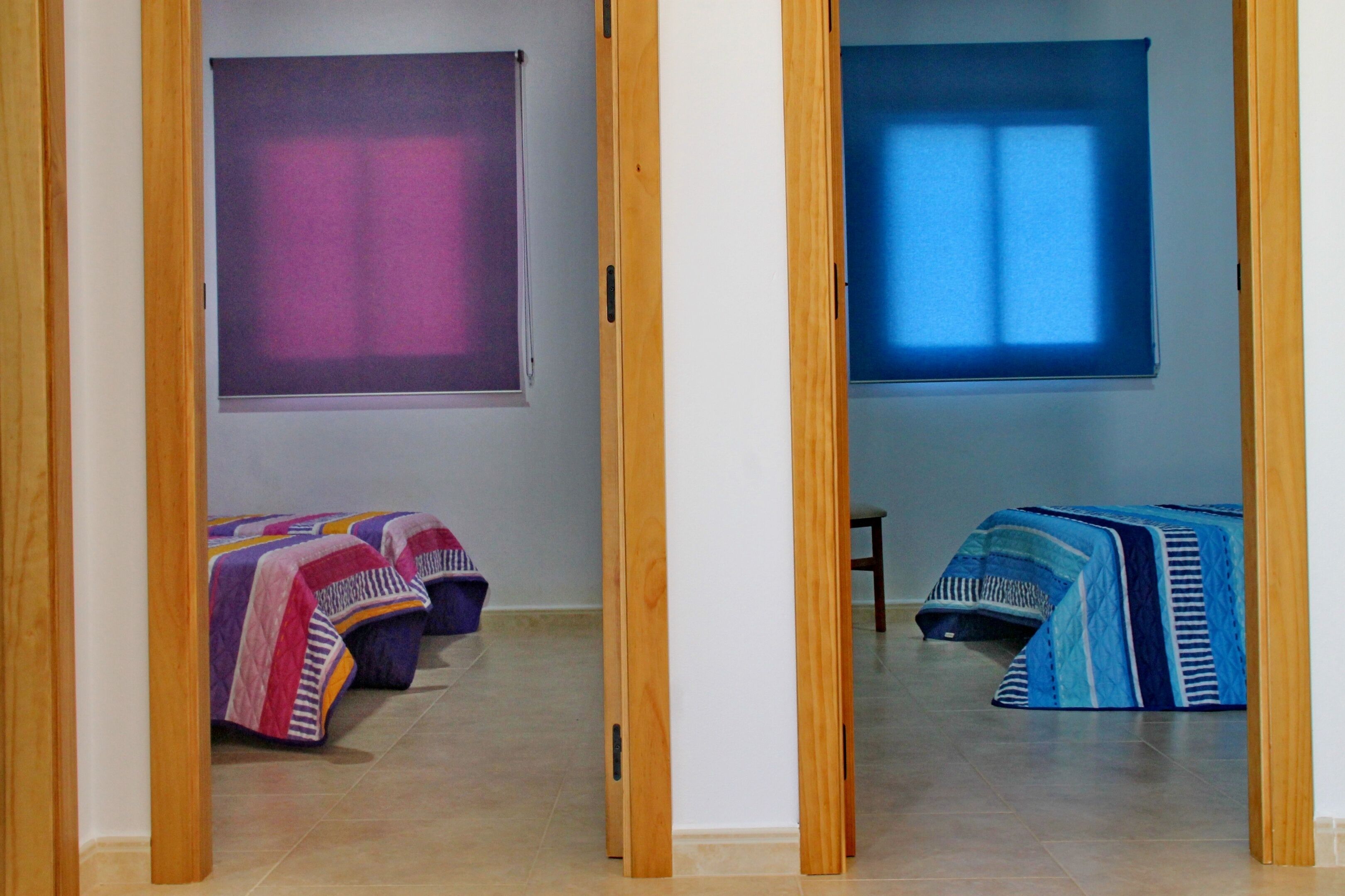 Une chambre avec deux lits, une fenêtre et une porte.