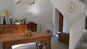 Ein Essbereich mit Holztisch und Stühlen, einer Kronleuchter und einem Wanddekor.