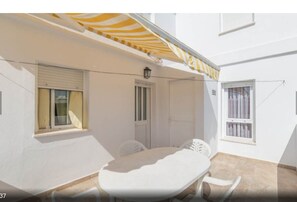A white room with a table, chairs, a window, and a door.
