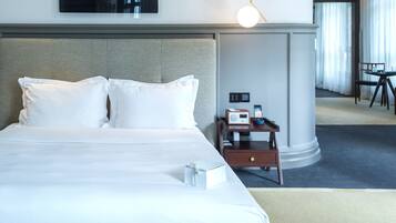 A hotel room with a large bed, a bedside table with a radio, and a view of the room's interior.
