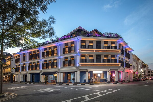 Een hotel met meerdere verdiepingen, in klassieke architectuur uitgevoerd, met balkons en een begane grond ingang.