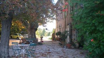 Une cour avec un chemin de gravier, un banc et une table.