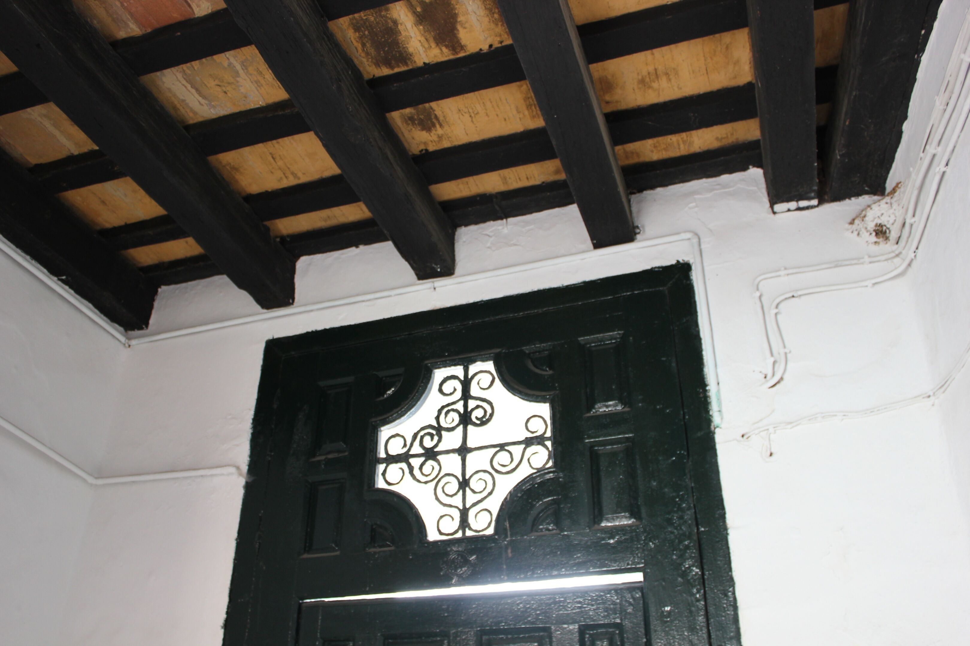Una puerta negra con un panel de vidrio decorativo.