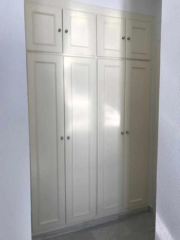 A white wardrobe with multiple doors and drawers. - Balcon Del Mar Primera Linea de Playa (Mijas)