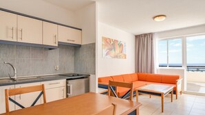 Una cucina compatta con zona pranzo, divano e un'ampia finestra che offre una vista.