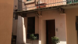 A building with a balcony, potted plants, and a door. - FROM IRENE                                                           (Bassano del Grappa)