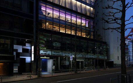 A modern building with multiple floors, large windows, and a prominent entrance.