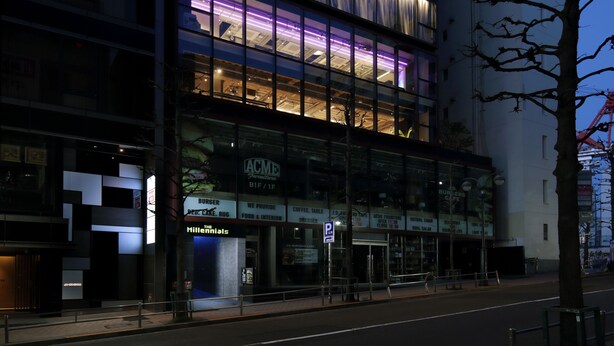 A modern building with multiple floors, large windows, and a prominent entrance.