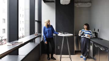 Een moderne keuken met een groot raam, een ronde tafel en een vaatwasser.