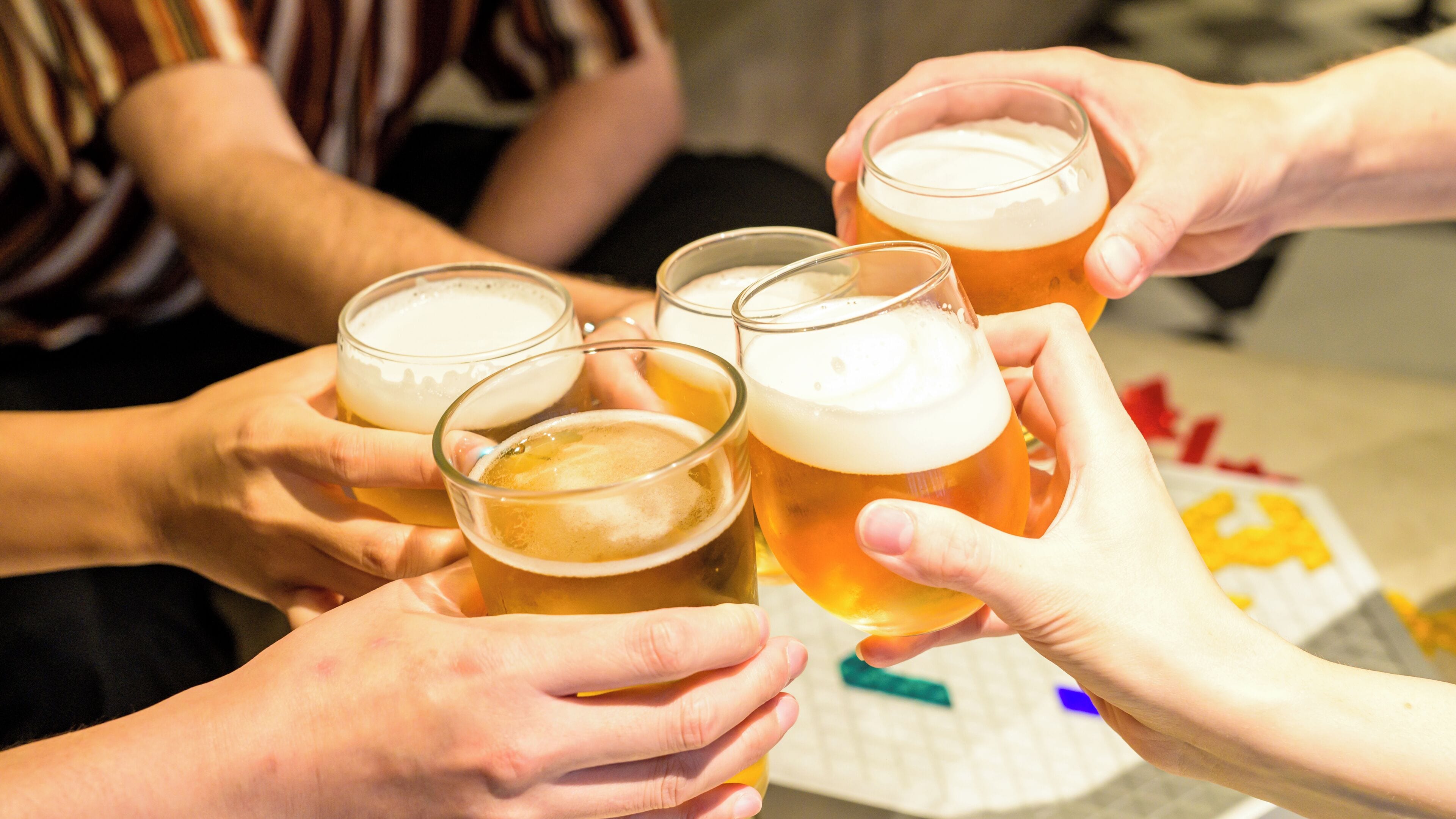 En gruppe mennesker holder ølglas, sandsynligvis i et festligt selskab.