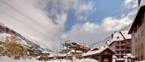 A snow-covered mountain resort with buildings, including a lodge marked "P3" and a sign for "TC Baierberg."