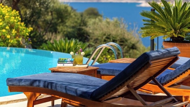 A poolside area with lounge chairs and a table with books and a drink. - Your Private Paradise Above the Sea (Kalkan Antalya)