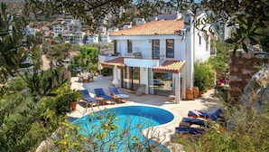 A modern villa with a swimming pool, sun loungers, and a view of the surrounding hillside. - Your Private Paradise Above the Sea (Kalkan Antalya)