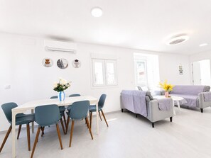 A modern living room with a dining area, a sofa, and a coffee table. - 3 bedroom apartment with WiFi near beach (Conil de la Frontera)