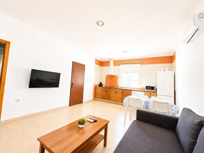 A living room with a sofa, a coffee table, and a TV. - Chalet Playa Roche . (Conil de la Frontera)