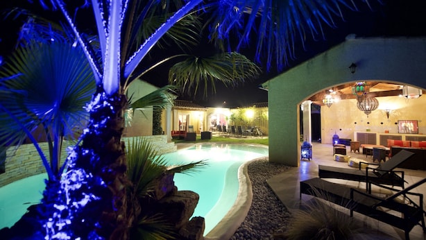 A pool area with lounge chairs and a bar area with seating and a chandelier. - Hacienda : 220m2 villa for 12 people with swimming pool, 5 minutes from the beach (Vic La Gardiole)