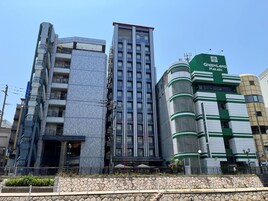 Un edificio moderno con fachada de vidrio y un cartel que dice 'Green Land Nakasu'.