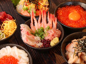 Diversos platos de mariscos, como camarones, caviar y sushi.