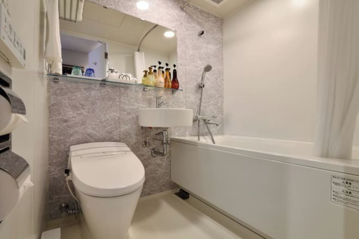 A bathroom with a toilet, sink, and bathtub.