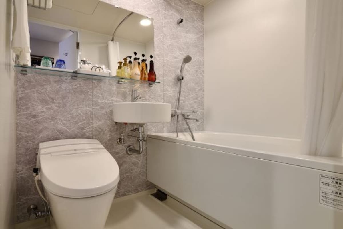 A bathroom with a toilet, sink, and bathtub.