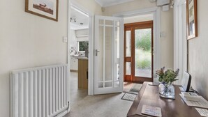 A room with a wooden table, a white radiator, a door leading to a balcony, and a framed picture on the wall. - Meadow View, Blue Anchor (Blue Anchor)