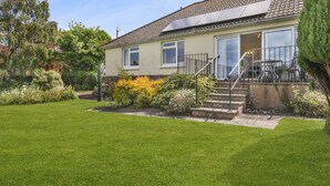 A two-story house with a front garden, a staircase leading to the entrance, and a visible door. - Meadow View, Blue Anchor (Blue Anchor)