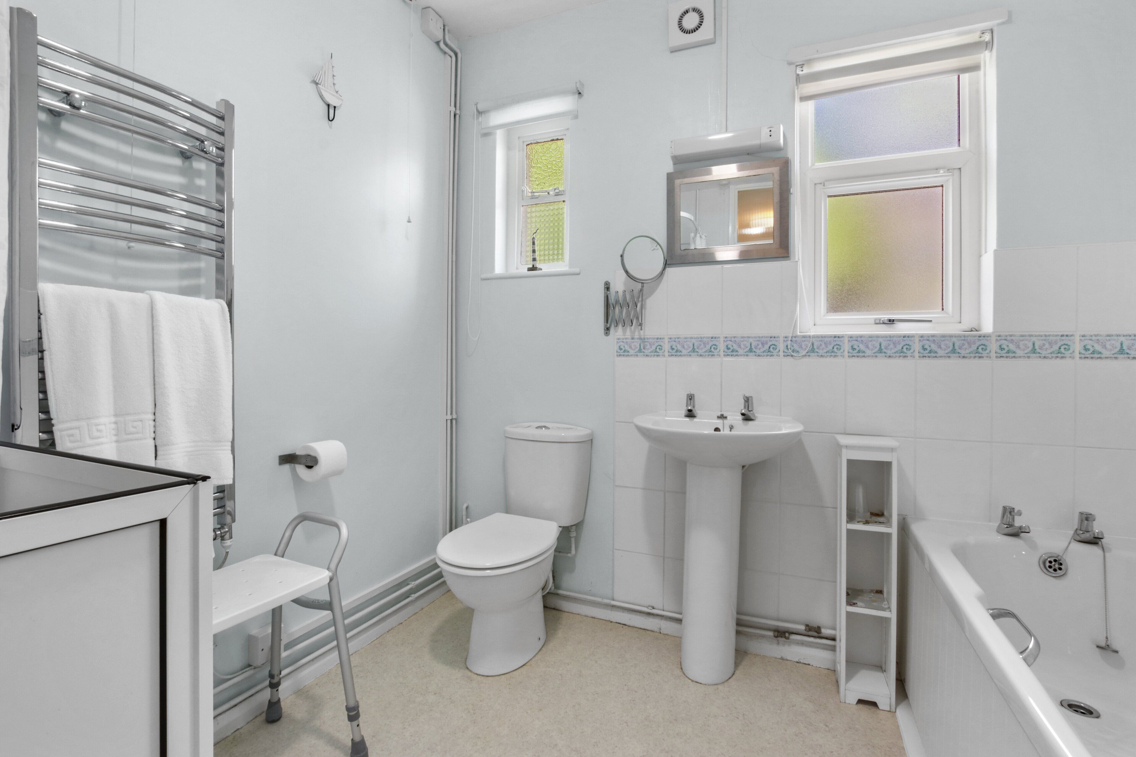 A modern bathroom with a toilet, sink, bathtub, and a window.