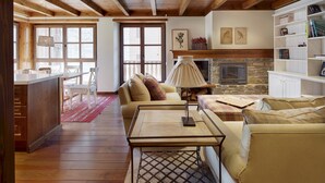 A cozy living room with a fireplace, wooden furniture, and a bookshelf. - Val de Ruda 46 by FeelFree Rentals (Naut Aran)