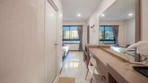 A modern hotel room with a large mirror, a wooden vanity, a bed, and a view of the outdoors. - The Moon Night Hotel (Bangkok)