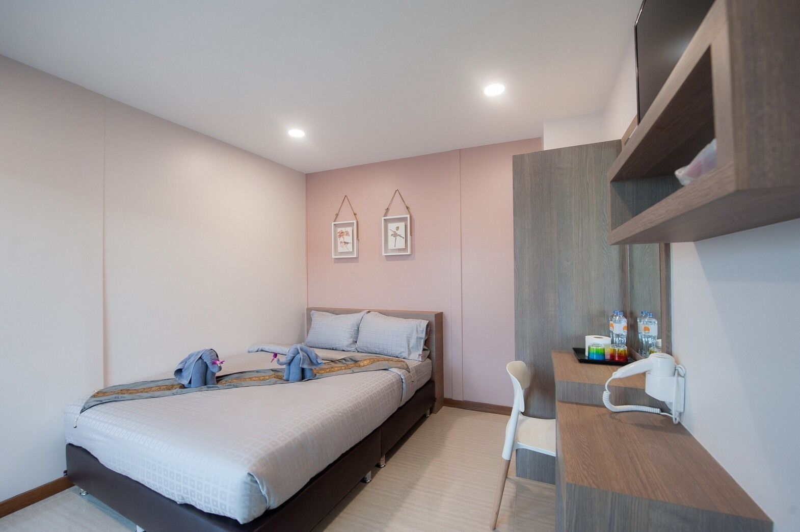 Un dormitorio moderno con cama, mesita de noche y espejo.