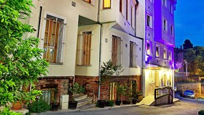 Un edificio de varios pisos con espacios residenciales y comerciales, destacando un frente de ladrillo, ventanas amplias y una entrada bien iluminada.