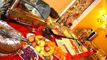 A buffet table with various food items and utensils.