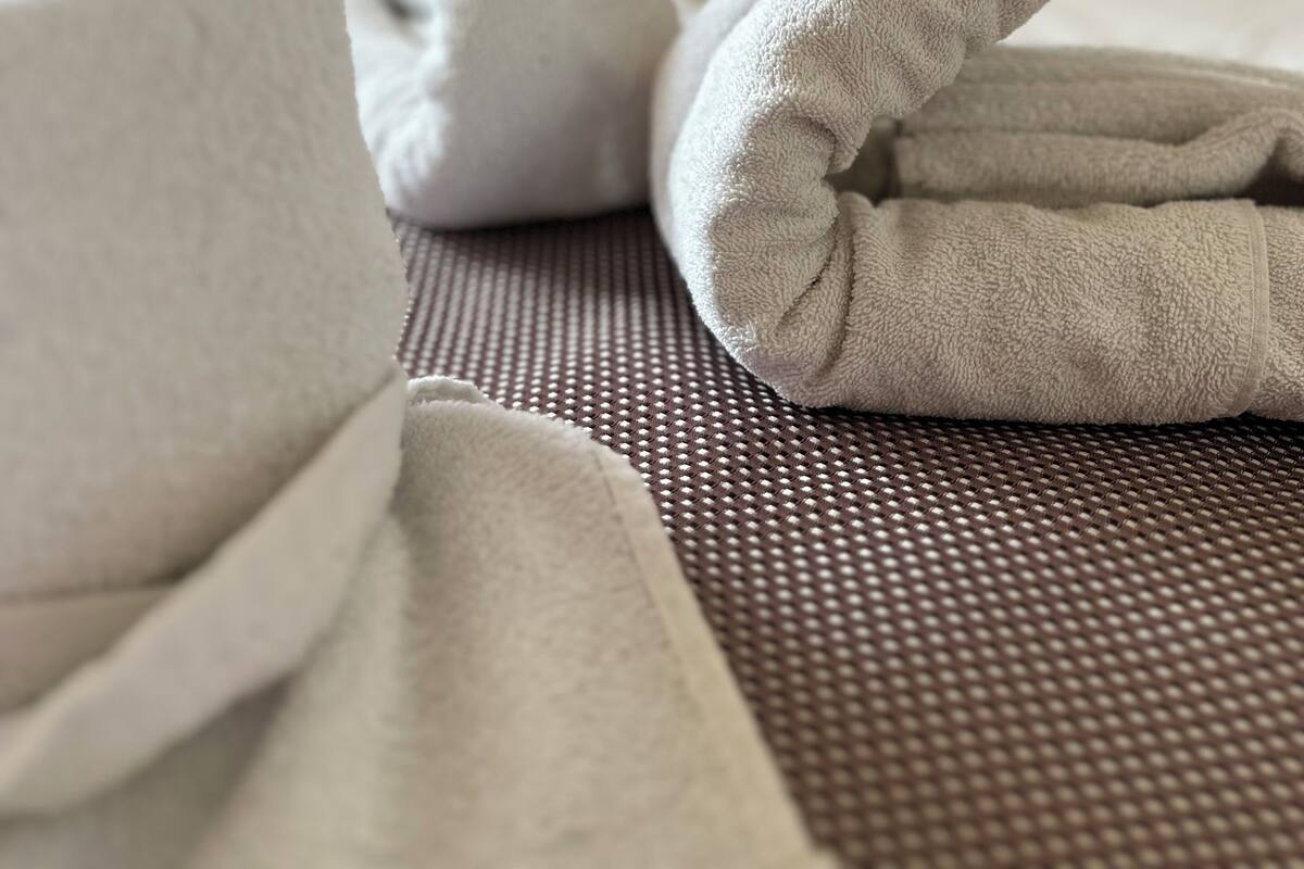 A neatly folded white towel on a textured surface.