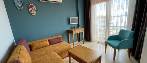 A living room with a sofa, a coffee table, a TV, and a chair.